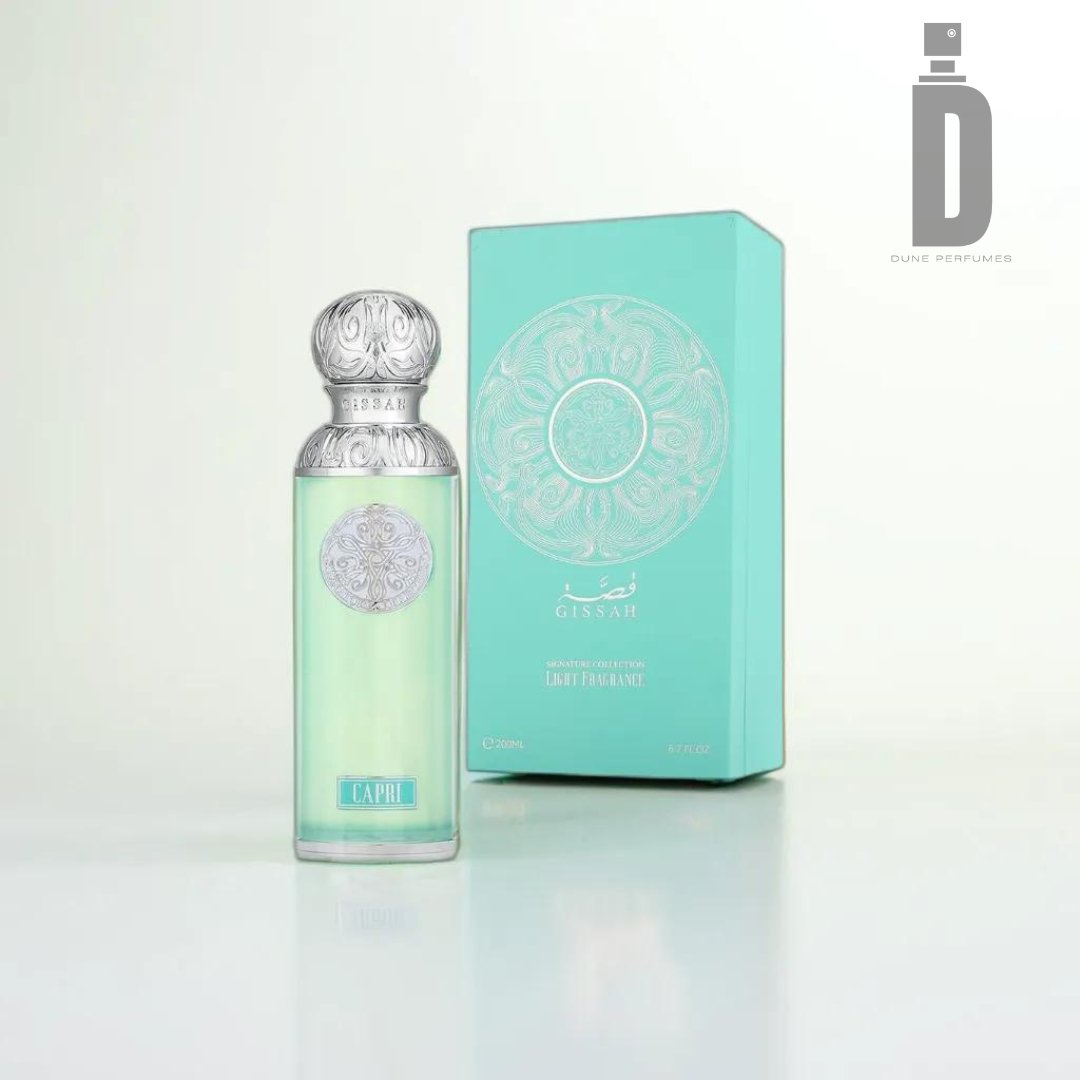 A Capri 200ml EDP by Gissah perfume bottle stands in front of its matching box. The bottle features a silver cap and green-tinted glass, beautifully reflecting the green and silver design of the box. The Dune Perfumes logo adorns the top right corner, emphasizing this dynamic fragrance that evokes a coastal escape.