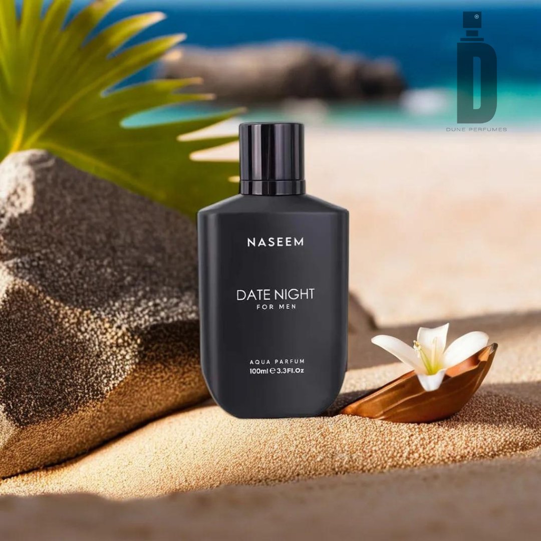 A black bottle of Date Night For Men 100ml Aqua Parfum - Naseem (alcohol-free) by Naseem Perfumes is placed on sandy terrain with a small white flower and a green palm leaf in the background. This alcohol-free fragrance offers a sophisticated olfactory experience, set against the backdrop of a serene beach with blurred water and sky in the distance.