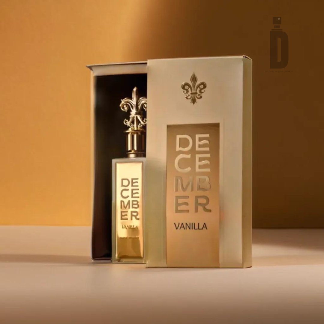 A glass bottle of "December Vanilla 85ml EDP - Paris Corner" perfume is placed in an open golden box. The box, exuding timeless elegance with its ornate detailing, proudly displays the brand name "Paris Corner" on the front. The background is a gradient of warm golden tones, enhancing the exquisite fragrance within.