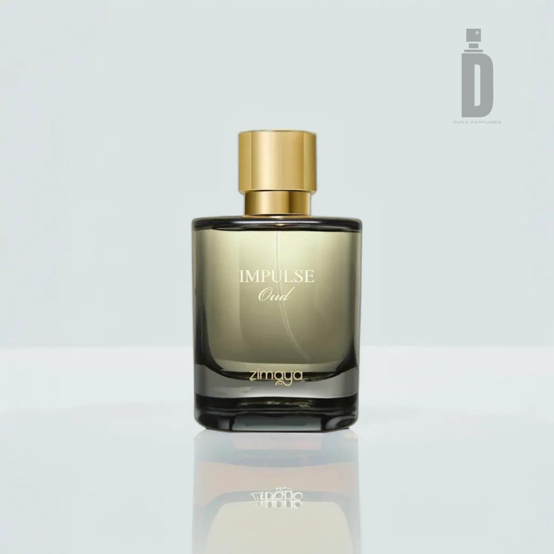 An elegant glass bottle of Impulse Oud 100ml EDP by Zimaya is placed against a light background. The bottle is rectangular with rounded edges and showcases a gradient color from dark at the bottom to lighter at the top. It features a gold cap and white text on the front, embodying a truly refined fragrance.