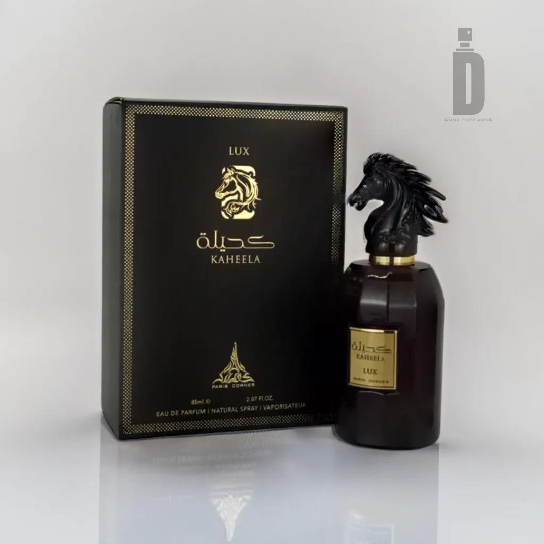 A dark rectangular perfume bottle with a sculpted horse head as the cap sits next to a black and gold box. Displaying Arabic script and the brand name "Paris Corner," this opulent fragrance, Kaheela Lux 85ml EDP - Paris Corner, exudes sophistication. The background remains plain and white, spotlighting the luxury perfume.