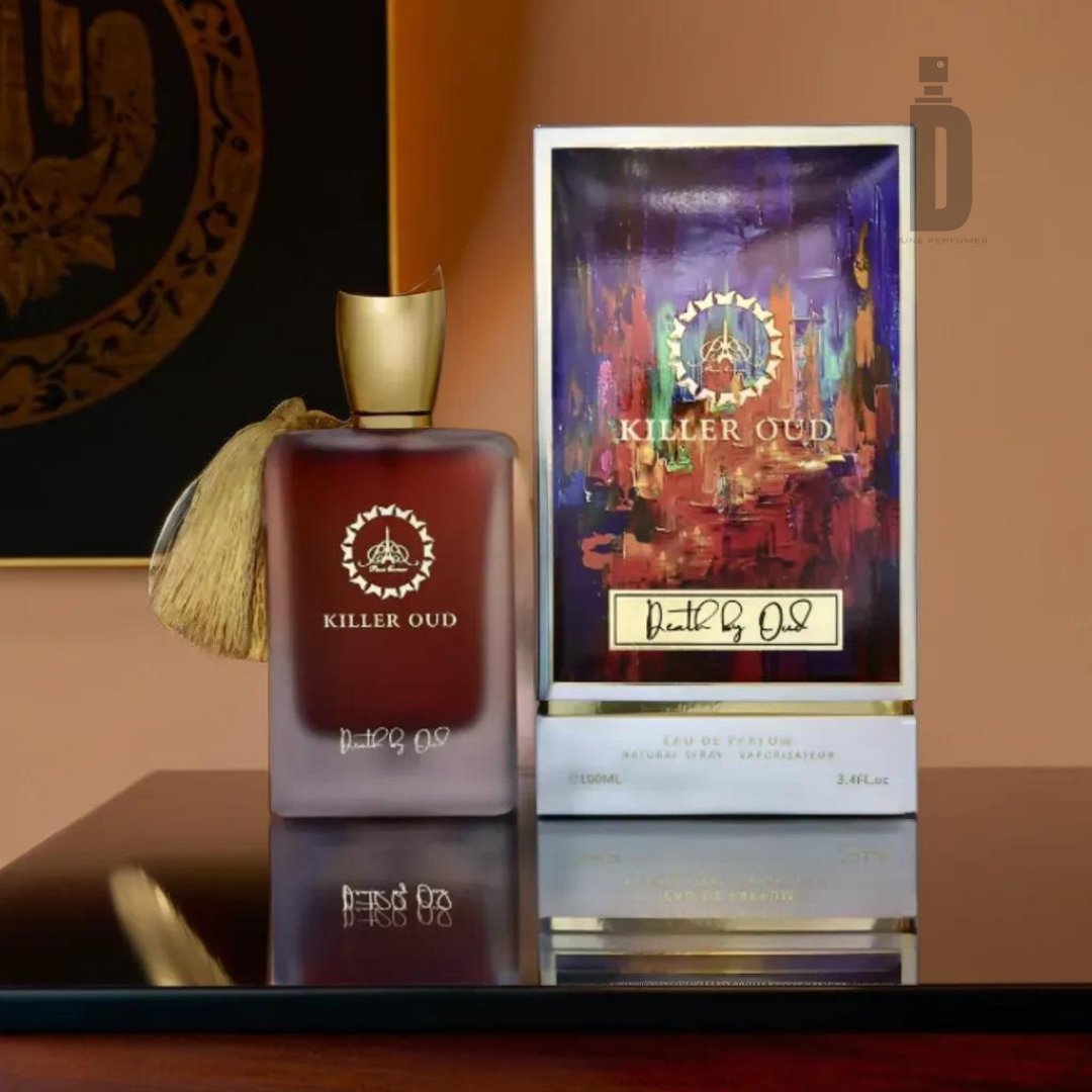 A bottle of "Killer Oud Death by Oud" fragrance from Paris Corner, adorned with a gold cap and tassel, sits on a reflective surface next to its vibrant, decorative packaging. The box features colorful abstract artwork and the same gold logo as seen on the "Death by Oud" perfume bottle.