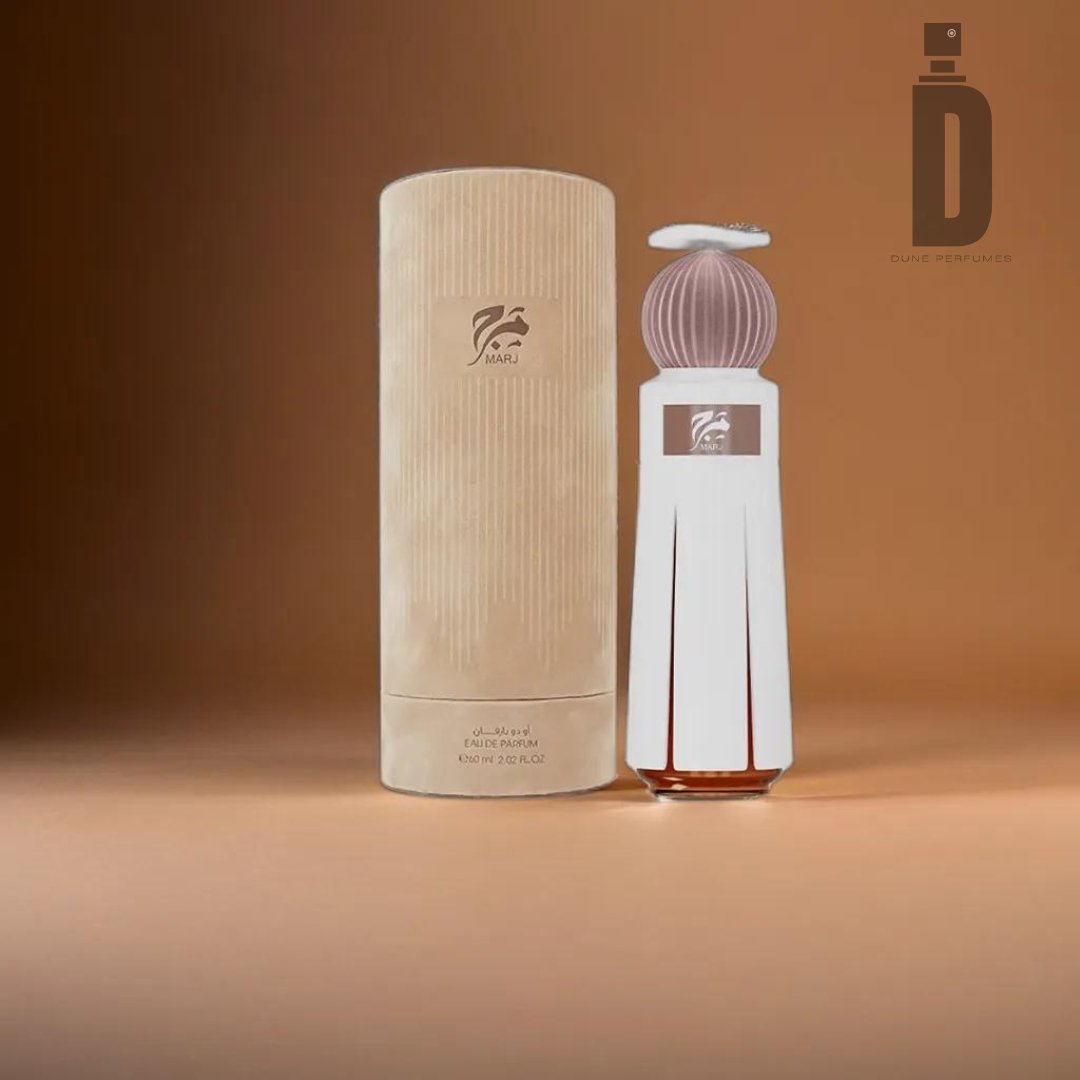 An elegantly designed perfume bottle with a white façade and a ribbed, pastel-colored cap is displayed next to its matching cylindrical box. The luxury perfume, "Marj 60ml EDP - Ahmed Al Maghribi," features a stylish logo and branding from Ahmed Al Maghribi. With its complex fragrance, it sits against a warm, light brown gradient background.