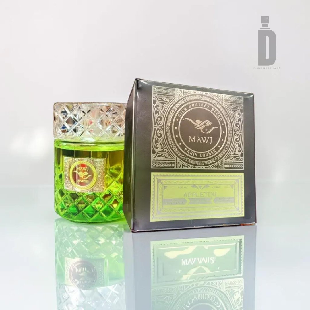 A perfume bottle filled with green liquid and adorned with a detailed, silver-patterned cap sits next to its rectangular, matching boxed packaging. Both the box and the bottle feature the Paris Corner brand logo and read "Mawj Appletini 100ml EDP - Paris Corner," presenting a captivating fragrance. A "D" logo is in the background.
