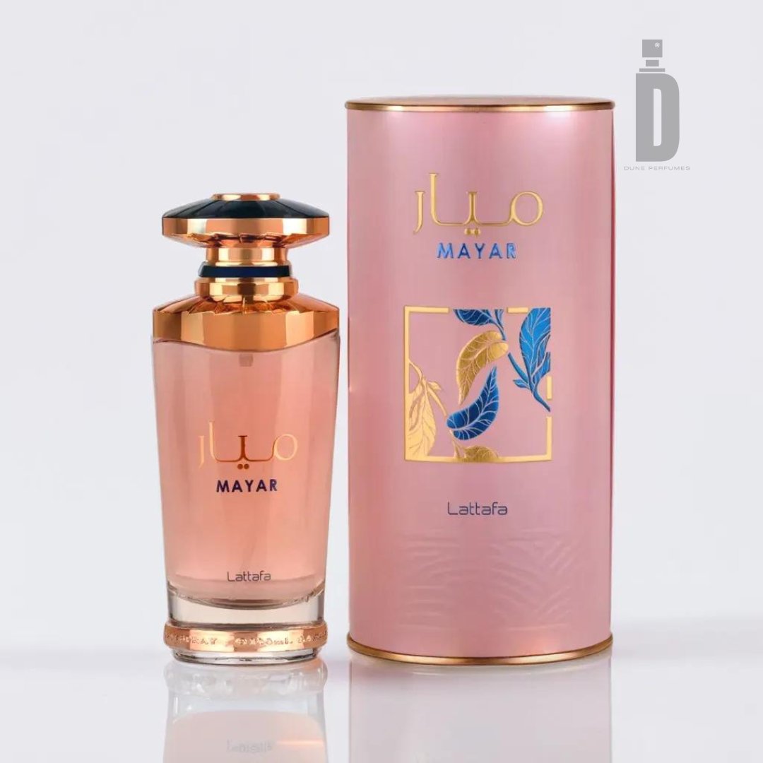A pink cylindrical perfume bottle with a gold cap exudes femininity as it stands next to its matching packaging. The elegant package features the brand name "Lattafa" and decorative illustrations of blue and gold leaves. The bottle also showcases the brand name and logo at the top, promising an exquisite fragrance within - this is the Mayar 100ml EDP by Lattafa.