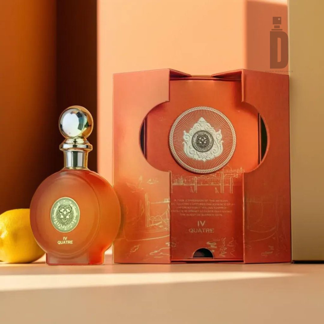 A bottle of North Stag Expressions 4 Quatre 100ml EDP from Paris Corner, adorned with a metallic stopper, is displayed next to its intricately designed matching orange and gold box. Both the bottle and the box feature elaborate patterns and a medallion emblem, capturing the elegance synonymous with Paris Corner's fragrance. To the left, a lemon peeks into view, blending smoothly with the soft gradients of peach and orange hues in the background, suggesting a hint of citrus within the fragrance.