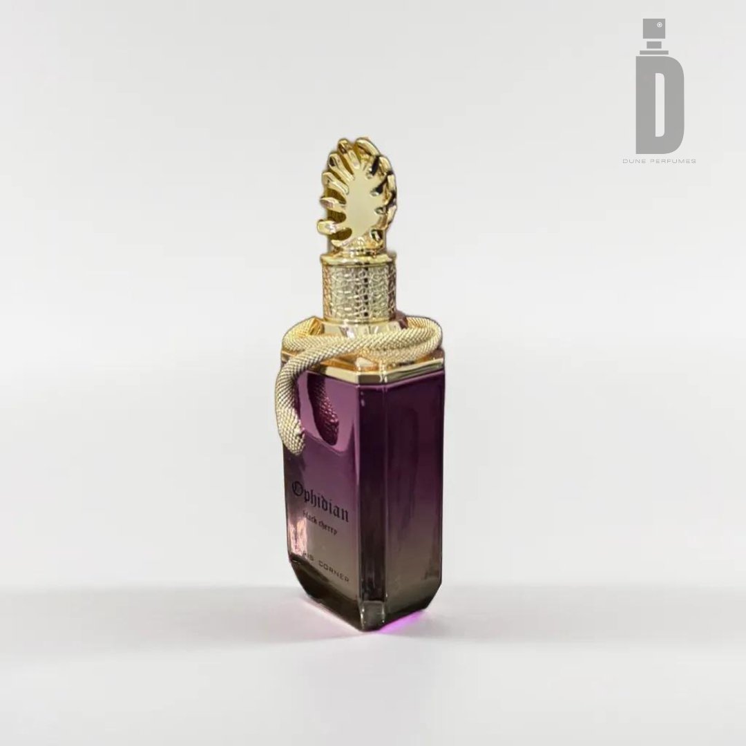A luxurious perfume bottle with a dark purple base and an intricately designed gold cap, featuring an ornate coiled snake detail. The label reads "Ophidian Black Cherry 100ml EDP" and "Paris Corner." Infused with fruity sweetness, this seductive fragrance promises allure. The background is plain light gray, showcasing the Paris Corner logo in the top right corner.