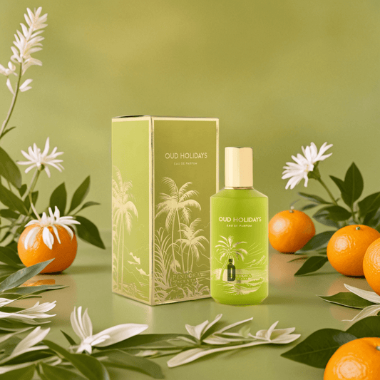 A green "Oud Holidays 100ml EDP" perfume bottle by Paris Corner, with its box, rests among oranges, white flowers, and leaves—capturing the luxurious scent of smoky oud on a lively green backdrop.