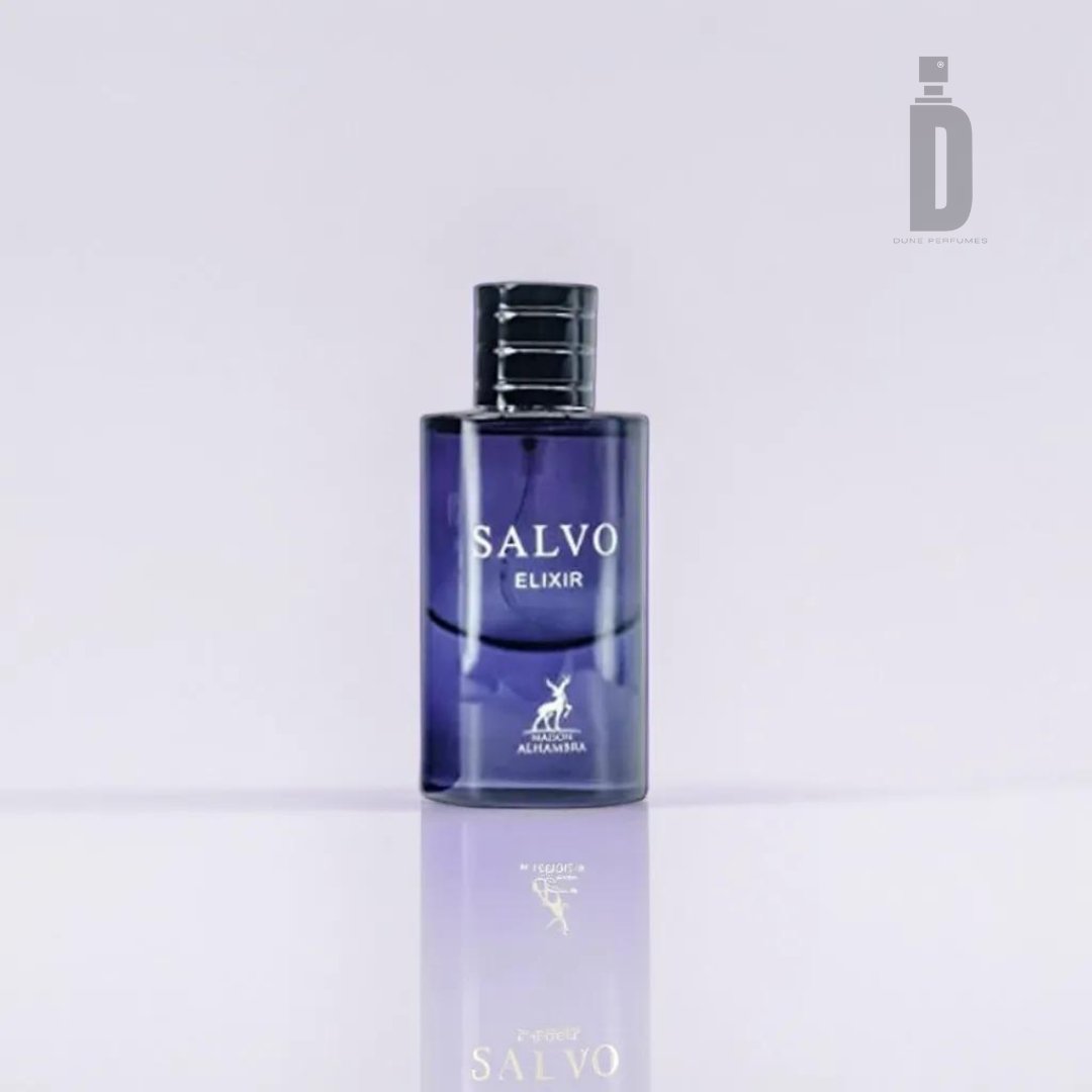 A clear glass perfume bottle with a dark blue tint labeled "Salvo Elixir 60ml EDP - Maison Alhambra" stands on a reflective surface, creating a mirrored effect at the bottom. The sophisticated bottle, with its black cap and "Maison Al Hambra" logo accompanied by a deer icon beneath the label, encapsulates the elegance of its fragrance.