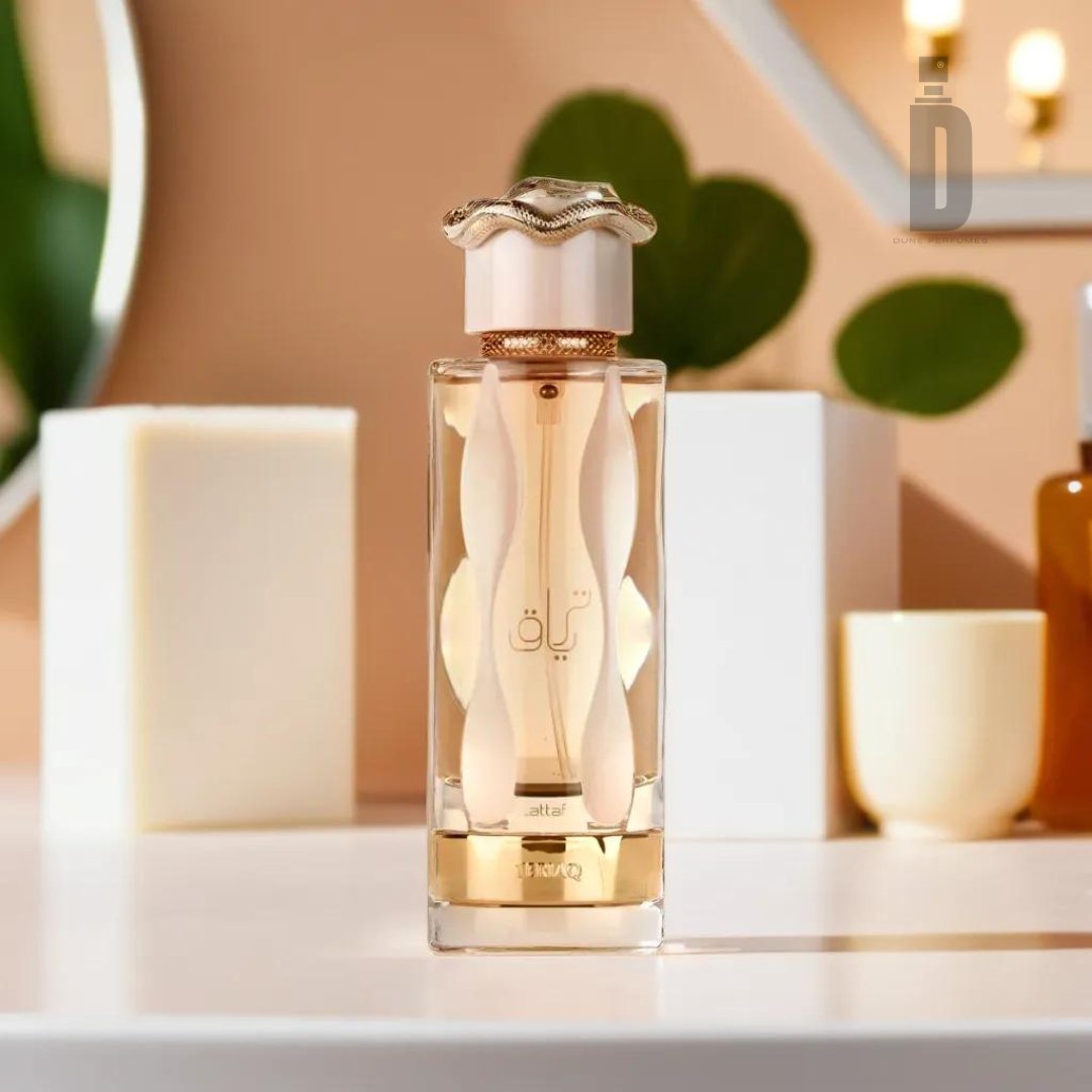 A 100ml bottle of Teriaq EDP by Lattafa, adorned with Arabic writing and showcasing a distinctive wavy design on the bottle along with an ornate cap. The enchanting fragrance is displayed on a white surface, surrounded by a plant and geometric decor elements in a softly lit ambiance.